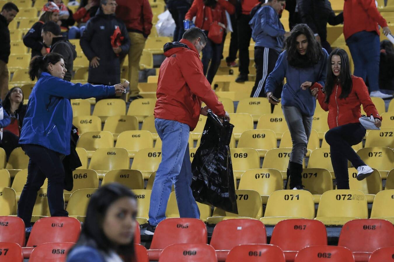 Hinchas de fútbol recogen basura del estadio