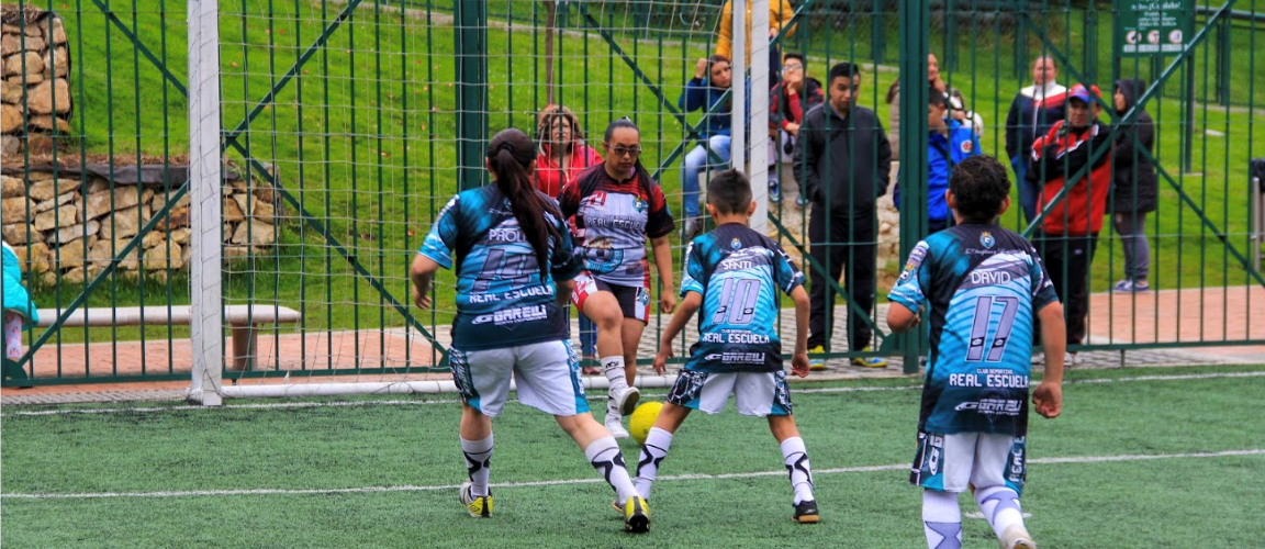 Madres juegan fútbol con sus hijos
