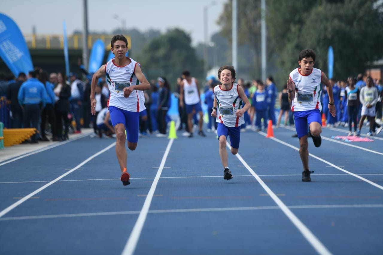 Niños corren en pista de atletismo