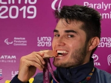 deportista mordiendo medalla