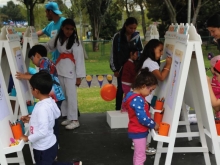 Niños pintan lienzos en parque