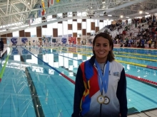 Deportista de natación con aletas posa con su medalla