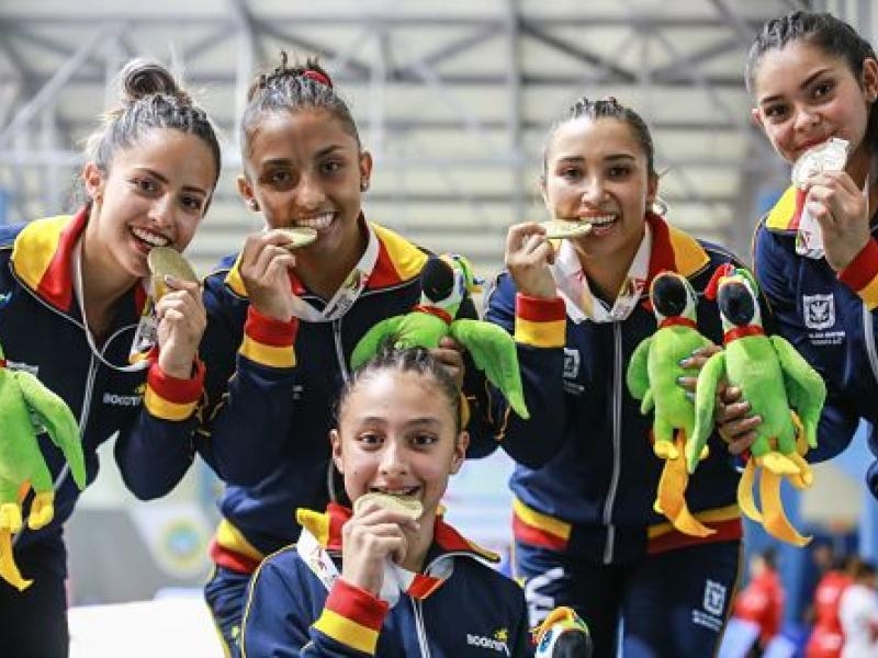 deportistas mordiendo medallas