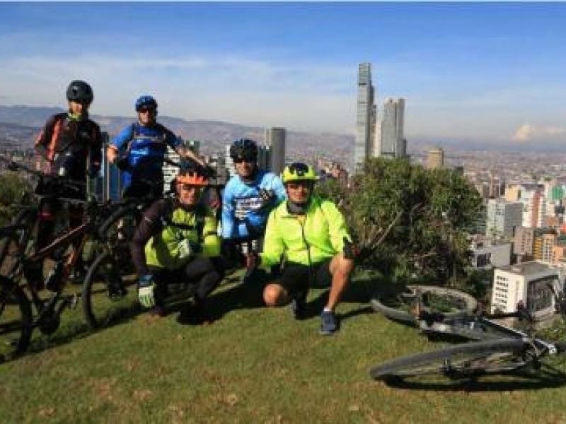 Ciclistas en un mirador y en el fondo la ciudad